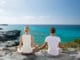 Pärchen macht Yoga in Spanien am Strand